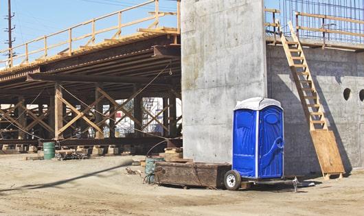 a lineup of sanitized portable restrooms on a busy work site